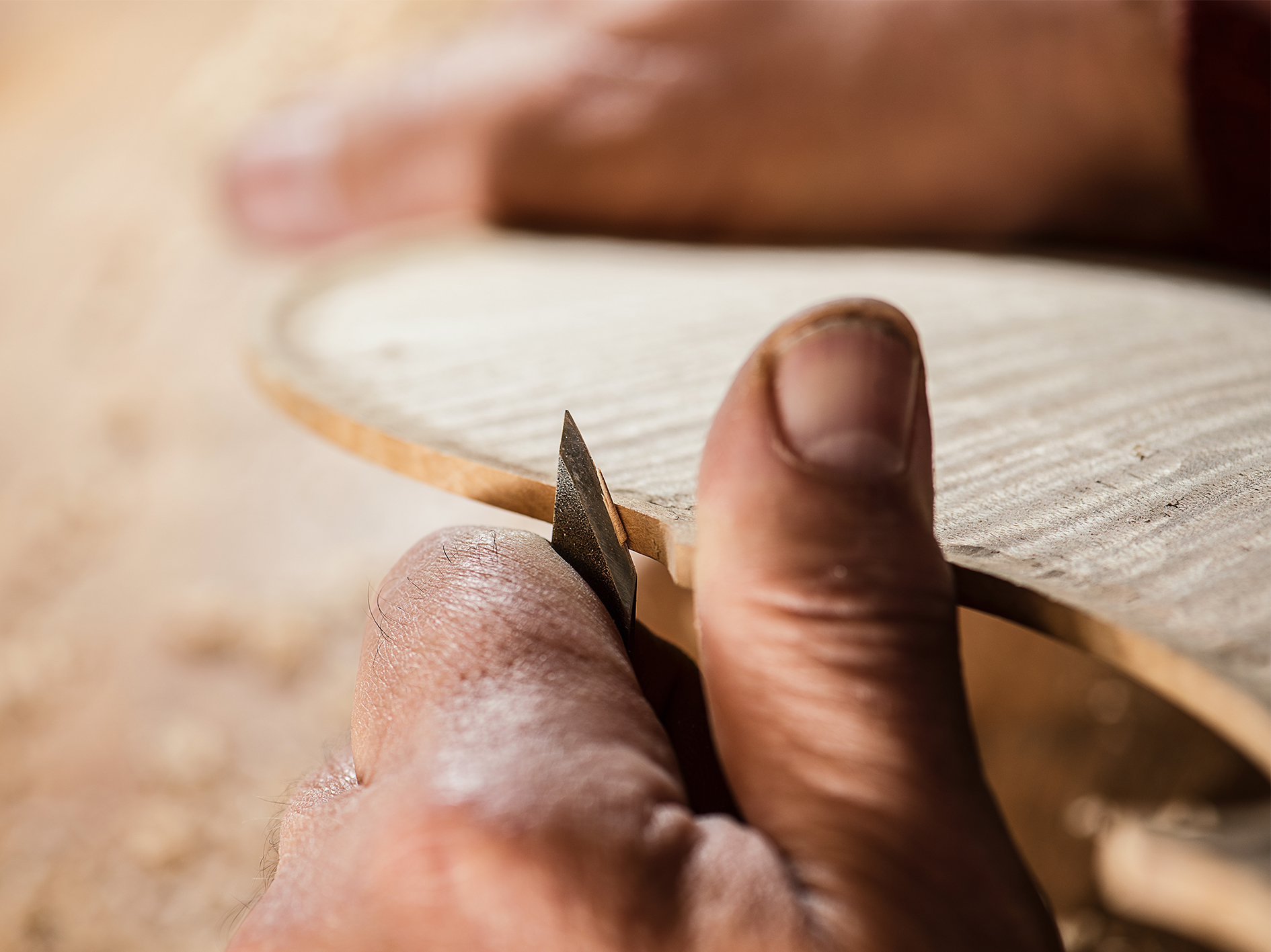 Image of luthier carving violin.